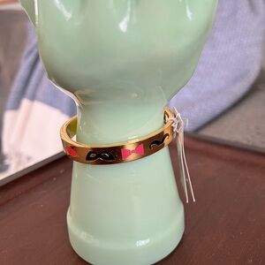 Kate Spade New York gold tone hinged bangle. “Blessing in Disguise” inside.